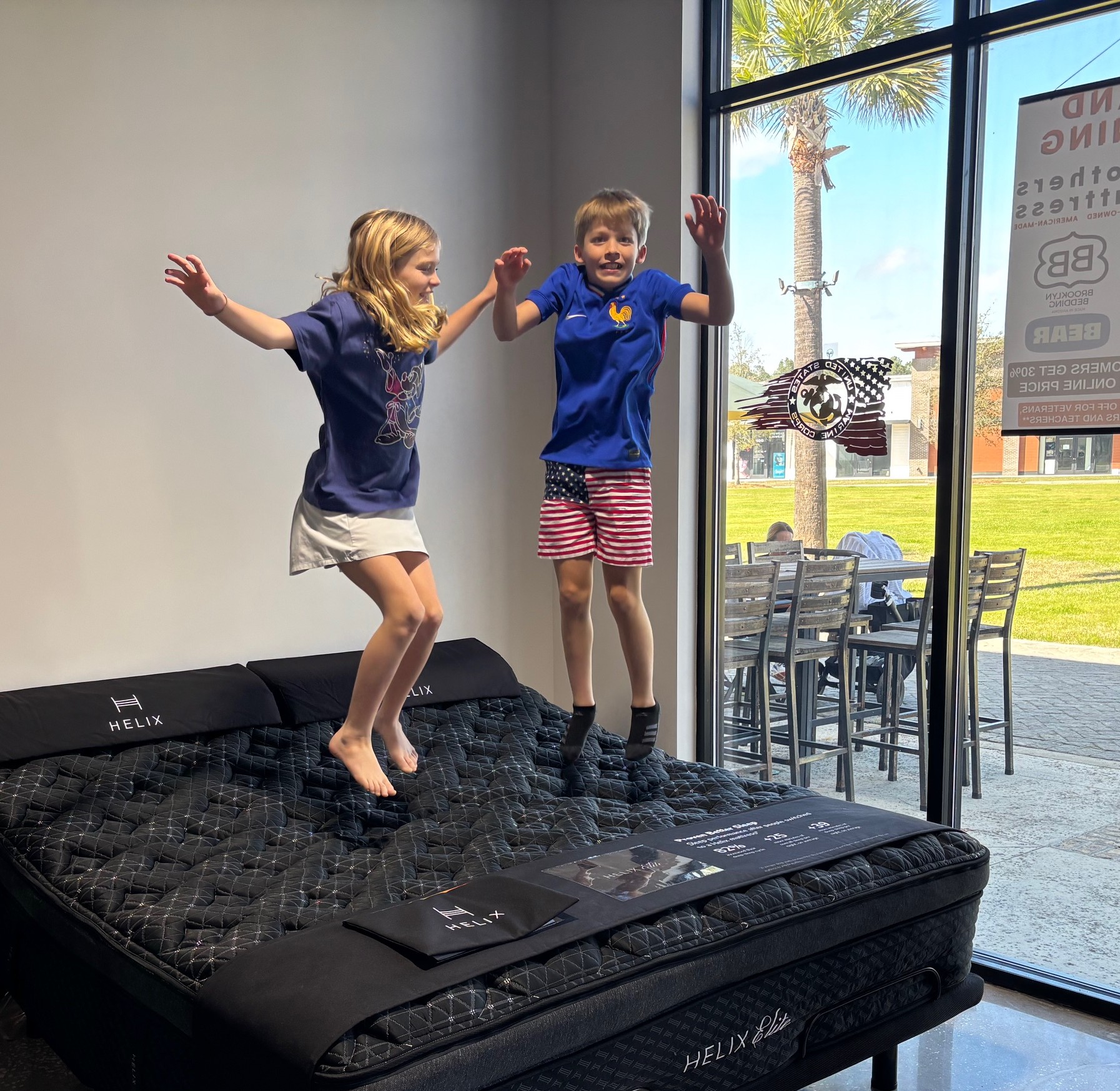 Justin’s children jumping on a mattress in the Brothers Mattress showroom